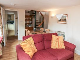 A living room with a sofa and dining table at Bridge Cottage Budleigh Salterton