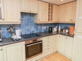A kitchen with cabinets and appliances at Bridge Cottage Budleigh Salterton