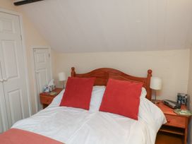A bedroom with a bed and bedside table at Bridge Cottage in Budleigh Salterton