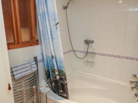 A bathroom with a bathtub and shower at Bridge Cottage in Budleigh Salterton