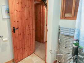 A bathroom with a wooden door and towel rack at Bridge Cottage Budleigh Salterton