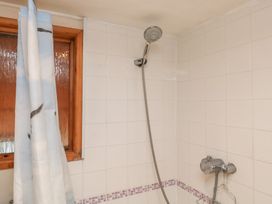 A shower with a curtain and window in the bathroom at Bridge Cottage Budleigh Salterton