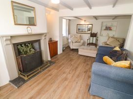 A living room with a fireplace and seating area at Greenways, Perranporth