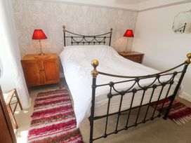 A bedroom with a bed, bedside tables, and lamps at Greenways in Perranporth