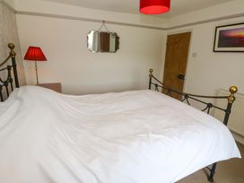 A bedroom with a bed and lamp at Greenways in Perranporth