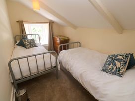 A bedroom with two beds and a window at Greenways in Perranporth