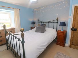 A bedroom with a bed and bedside table at Greenways in Perranporth