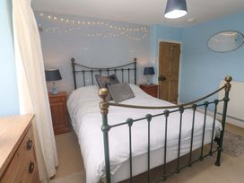 A bedroom with a bed and nightstands at Greenways in Perranporth