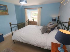 A bedroom with a bed and window at Greenways in Perranporth