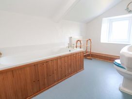 A bathroom with a bathtub and toilet at Greenways in Perranporth
