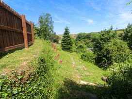 A garden with a fence, grass, flower, tree and path at Greenways in Perranporth