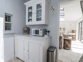 A kitchen with a microwave and cupboard at 8 Gloucester Street