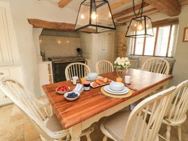 A kitchen with a dining table and breakfast items at 8 Gloucester Street Winchcombe