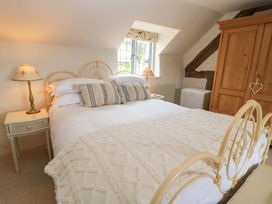 A bedroom with a bed and lamp at 8 Gloucester Street in Winchcombe
