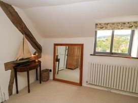 A bedroom with a mirror and sailing boat on a table at 8 Gloucester Street Winchcombe