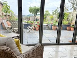 A conservatory overlooking a garden at The Garden Retreat in Winchcombe