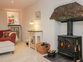 A living room with a fireplace and bookshelf at Brockstones in Grasmere