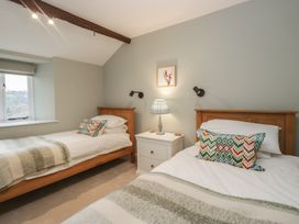 A bedroom with two beds and a nightstand at Brockstones in Grasmere