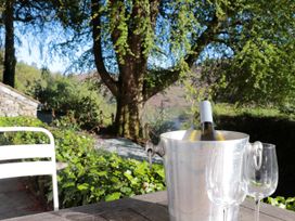 An outdoor setting with a wine bottle in an ice bucket and glasses at Brockstone in Grasmere