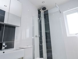 A bathroom with a sink a toilet a shower with glass door and a window at Bay View in Portreath