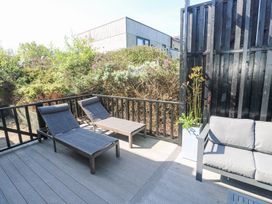 An outdoor deck with two lounge chairs a sofa and a planter with plants at Bay View in Portreath
