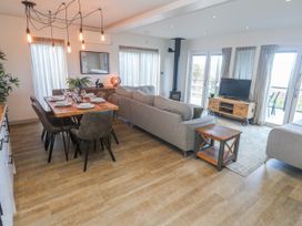 A living room with a dining area and television at Bay View in Portreath
