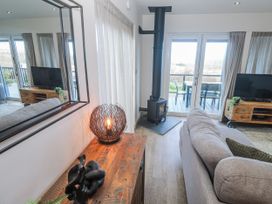 A living room with a television and wood stove at Bay View in Portreath