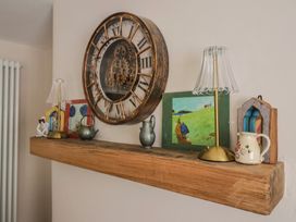 A wooden shelf with a clock, lamp, and decorative items at 6 Bedford Place in Bridport