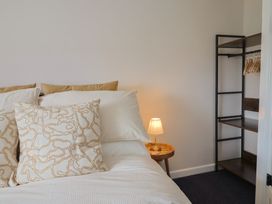 A bedroom with a bed and a clothes rack at 6 Bedford Place in Bridport
