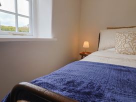 A bedroom with a bed and lamp at 6 Bedford Place in Bridport