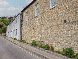 A street view with stone wall and plants at 6 Bedford Place in Bridport