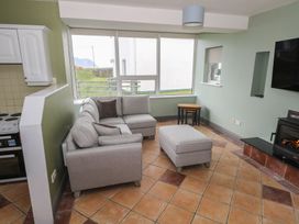 A living room with a couch and ottoman at No.3 Beach Cottages in Keel, County Mayo