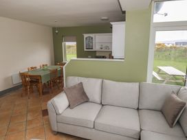 A living room with a sofa and dining area at No.3 Beach Cottages in Keel, County Mayo