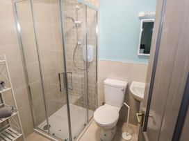 A bathroom with a shower, toilet, and sink at No.3 Beach Cottages, Keel, County Mayo
