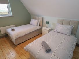 A bedroom with two single beds and a nightstand at No.3 Beach Cottages, Keel, County Mayo