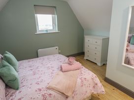 A bedroom with a bed and dresser at No.3 Beach Cottages, Keel, County Mayo