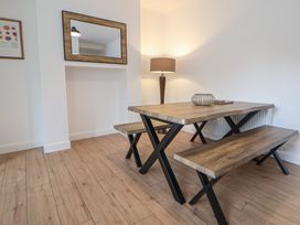 A dining table with benches and a lamp at 5 Marsh Lane Flint