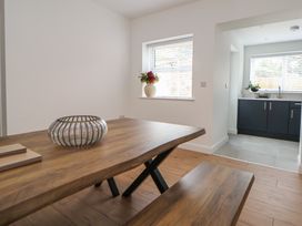A dining room with a table and benches at 5 Marsh Lane Flint