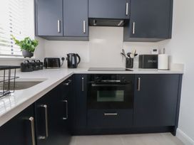 A kitchen with dark cabinets and white countertop at 5 Marsh Lane Flint