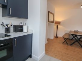A kitchen with a stove and dining area at 5 Marsh Lane in Flint
