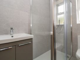 A bathroom with a sink, shower, and toilet at 5 Marsh Lane in Flint