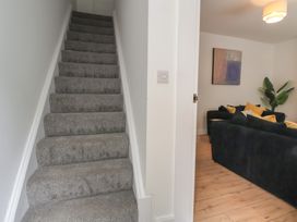 Stairs leading to living room with sofa and artwork at 5 Marsh Lane in Flint