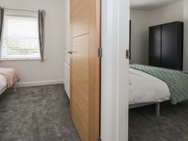 A bedroom with two beds and a window at 5 Marsh Lane Flint