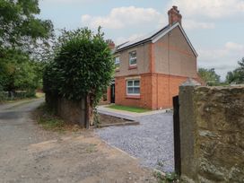 A house with a gravel pathway and bushes at 5 Marsh Lane in Flint