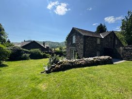A house with a garden and stone wall at Stone Arthur Cottage in Grasmere