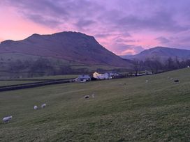 A field with sheep and a farmhouse at Stone Arthur Cottage Grasmere