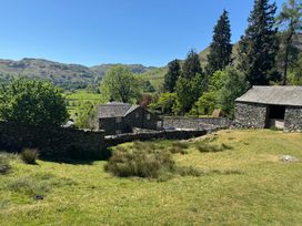 An outdoor area with a house and stone wall at Stone Arthur Cottage in Grasmere