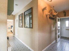 A hallway with animal head wall decorations and framed pictures near a bedroom at Waterside Lodge near Annan