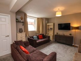 A living room with sofas and a television at The Corner House in Scarborough