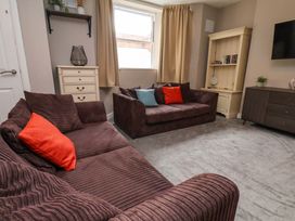A living room with sofas and a window at The Corner House in Scarborough